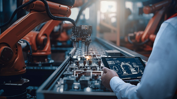 Engineers test the control of robot arm, Intelligent machine in factory industrial on real-time monitoring system software. Robots weld workpieces and produce industrial parts to reduce human labor.