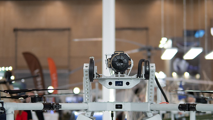 A drone featuring advanced surveillance equipment is showcased at a military expo, highlighting innovations in modern warfare and defense strategies.